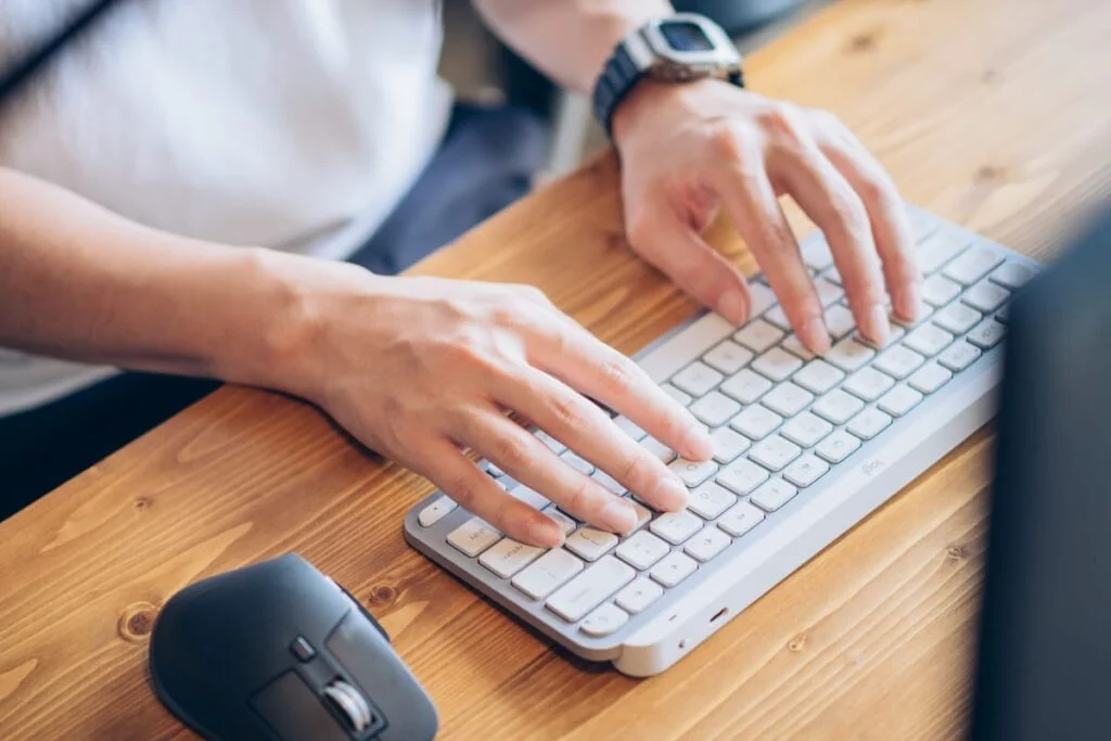 飲み物の近くでMacBookを使うイメージ